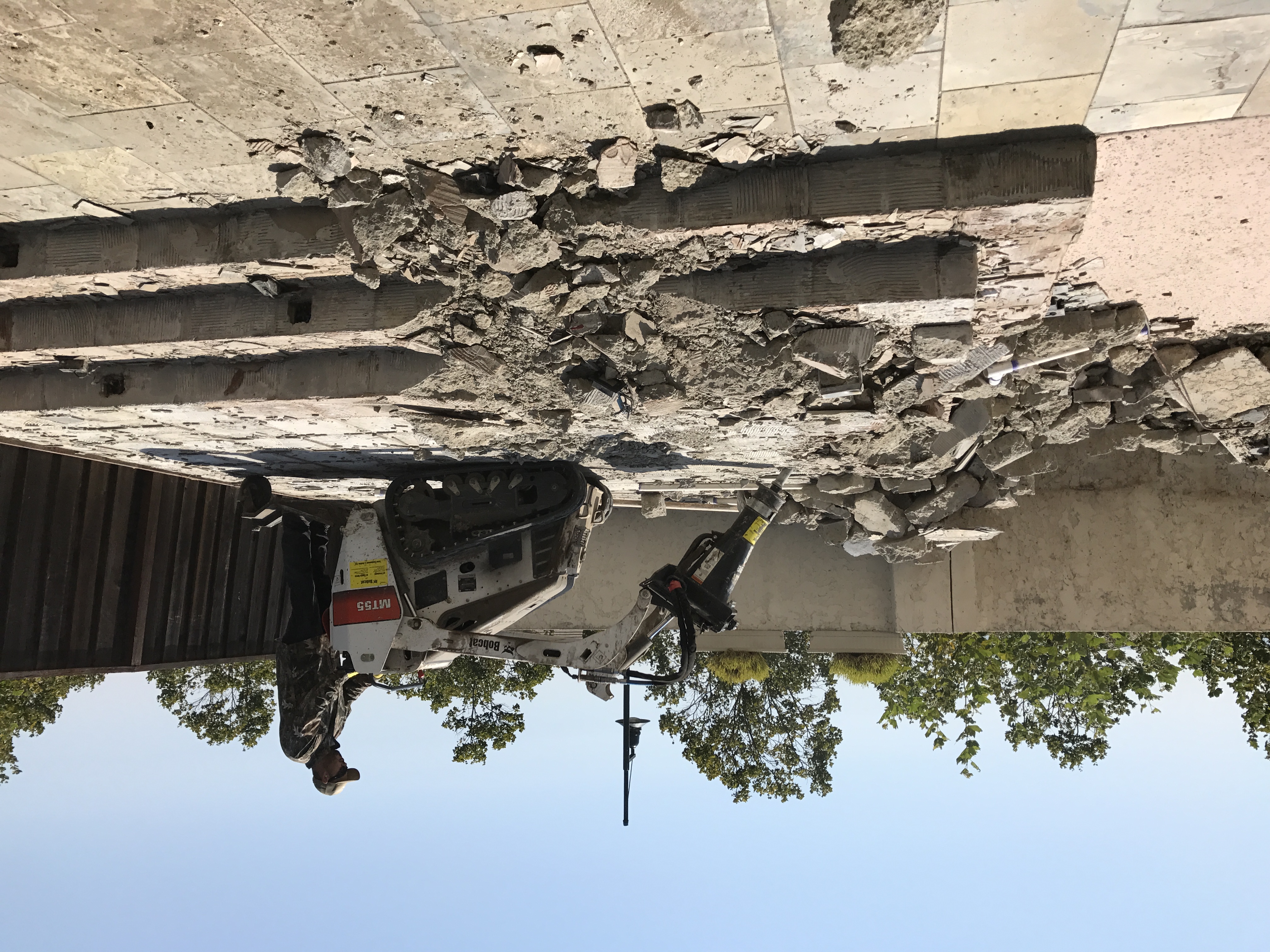 Patio demolition in progress with compact equipment