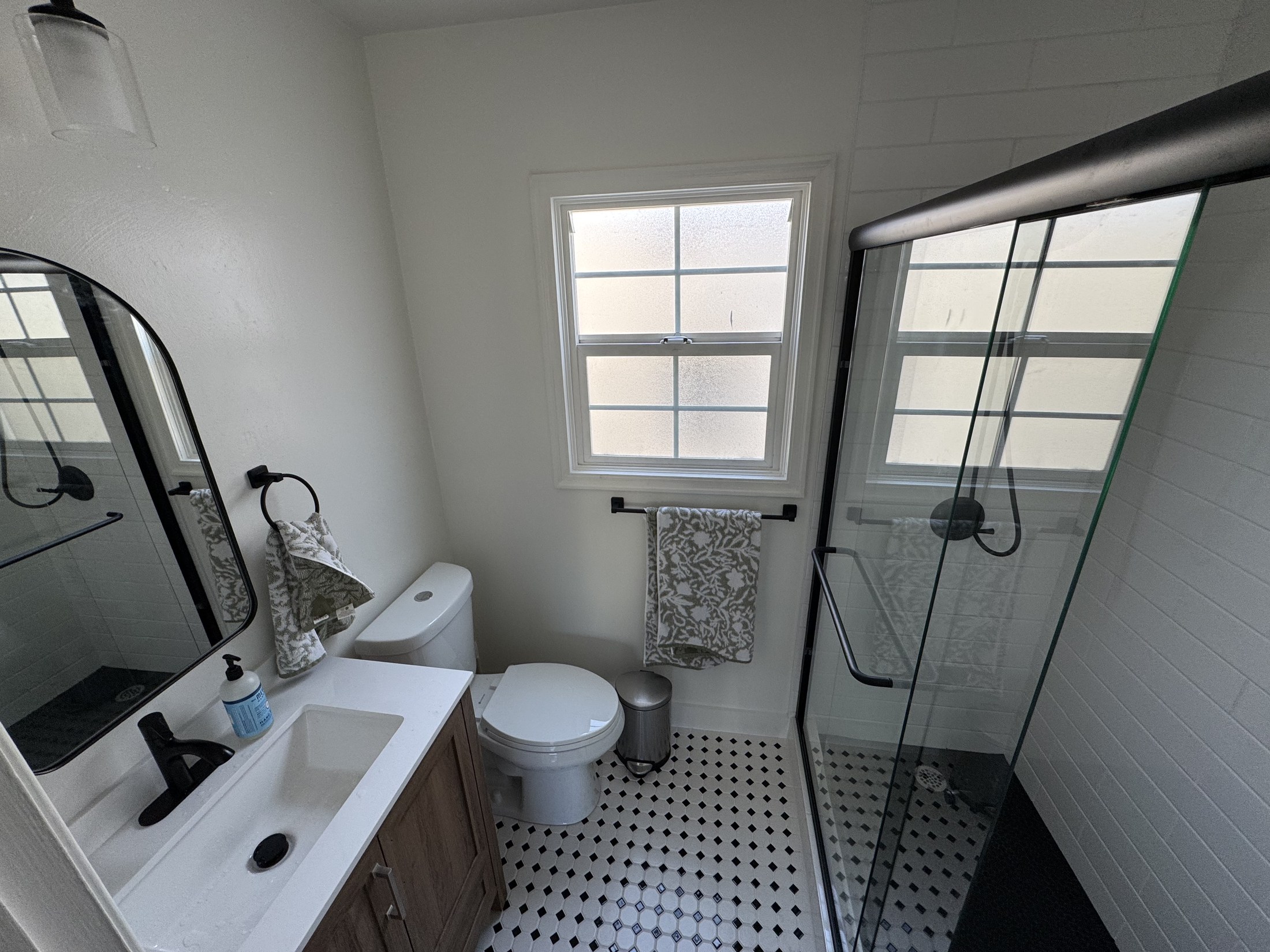 Finished bathroom with glass shower and vanity by 360 Construction JN