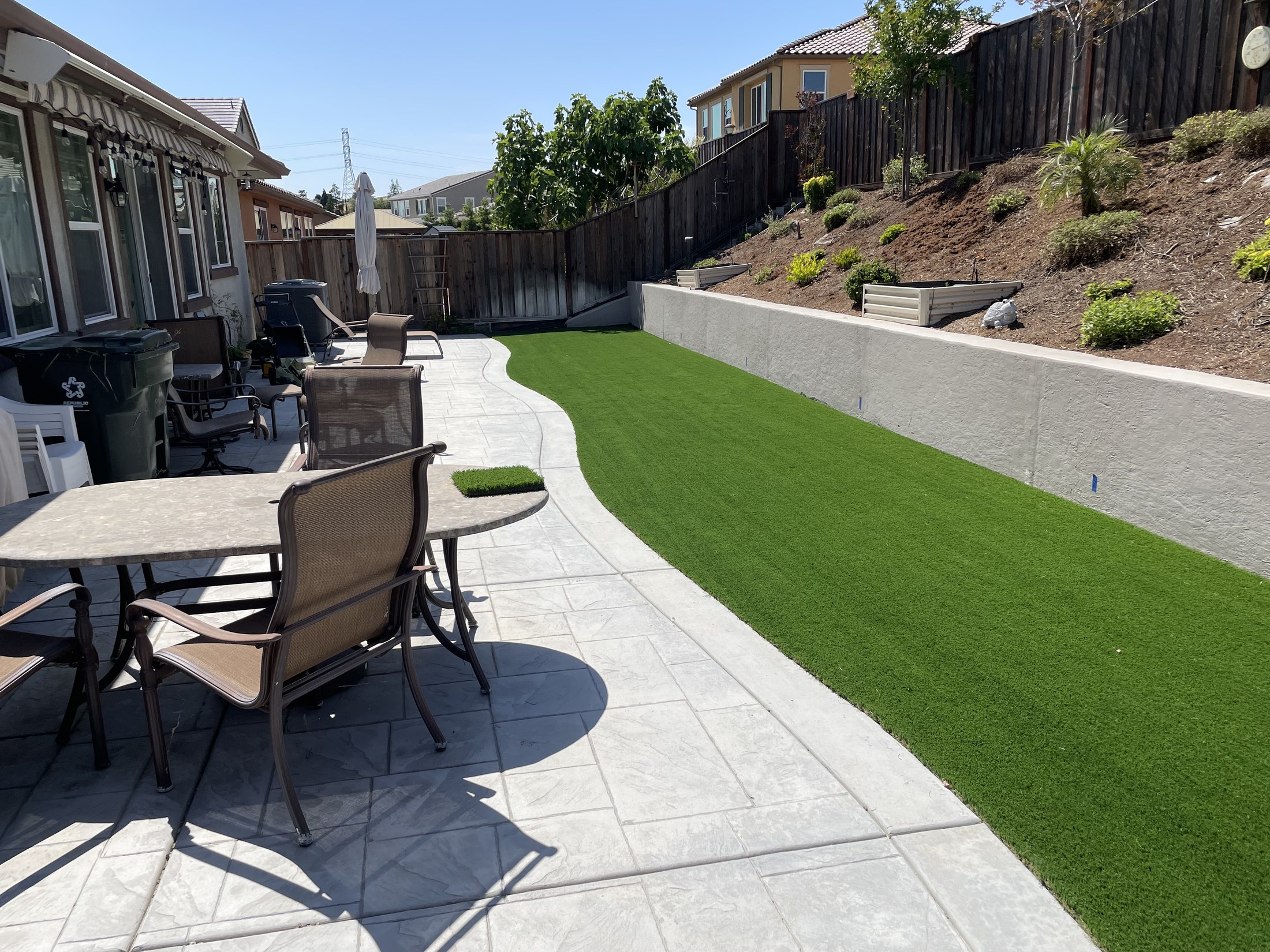 Finished concrete patio and turf backyard by 360 Construction JN